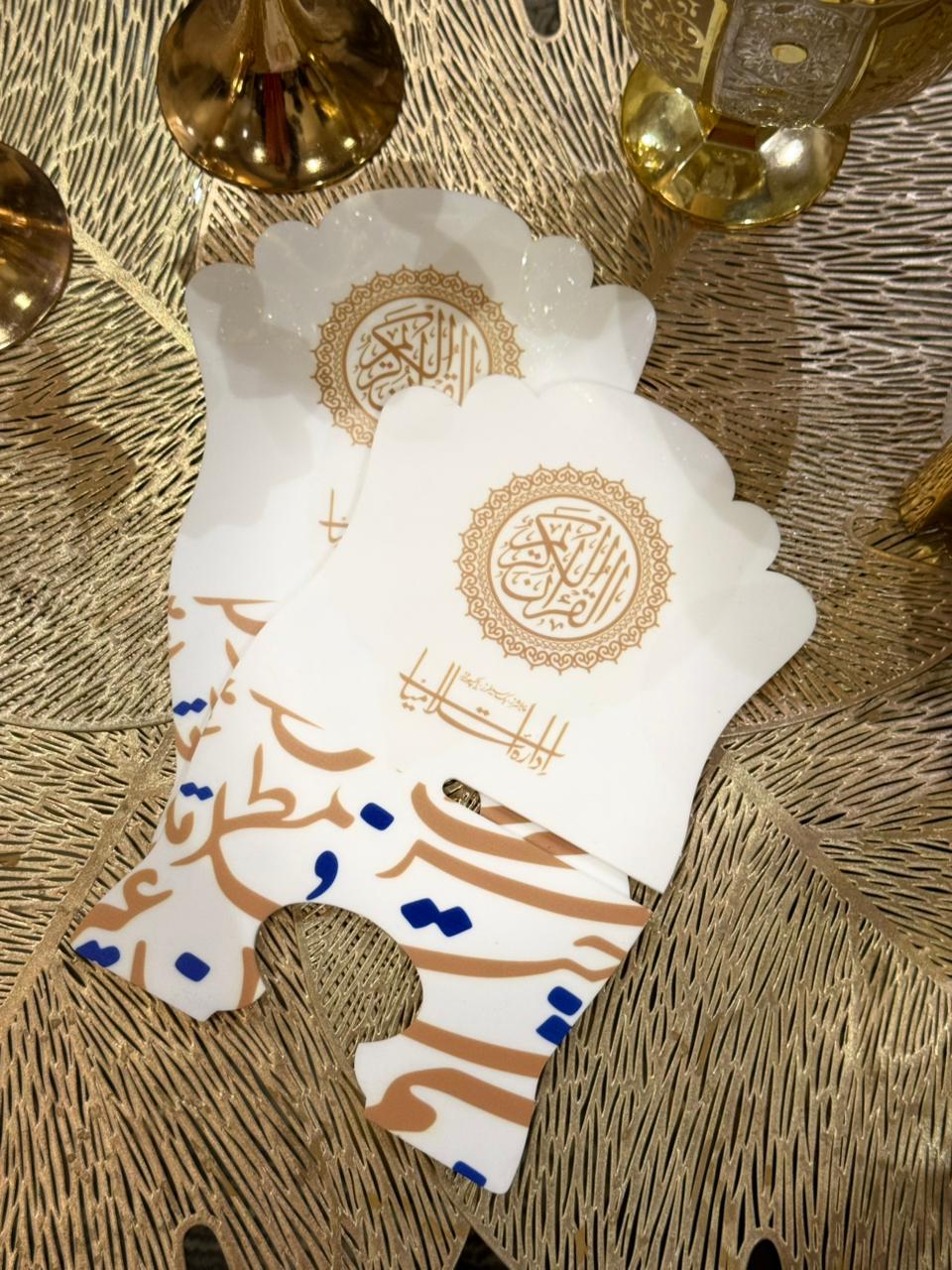 White Rehal with gold and blue designs on a textured gold surface by Idara-e-islamiat