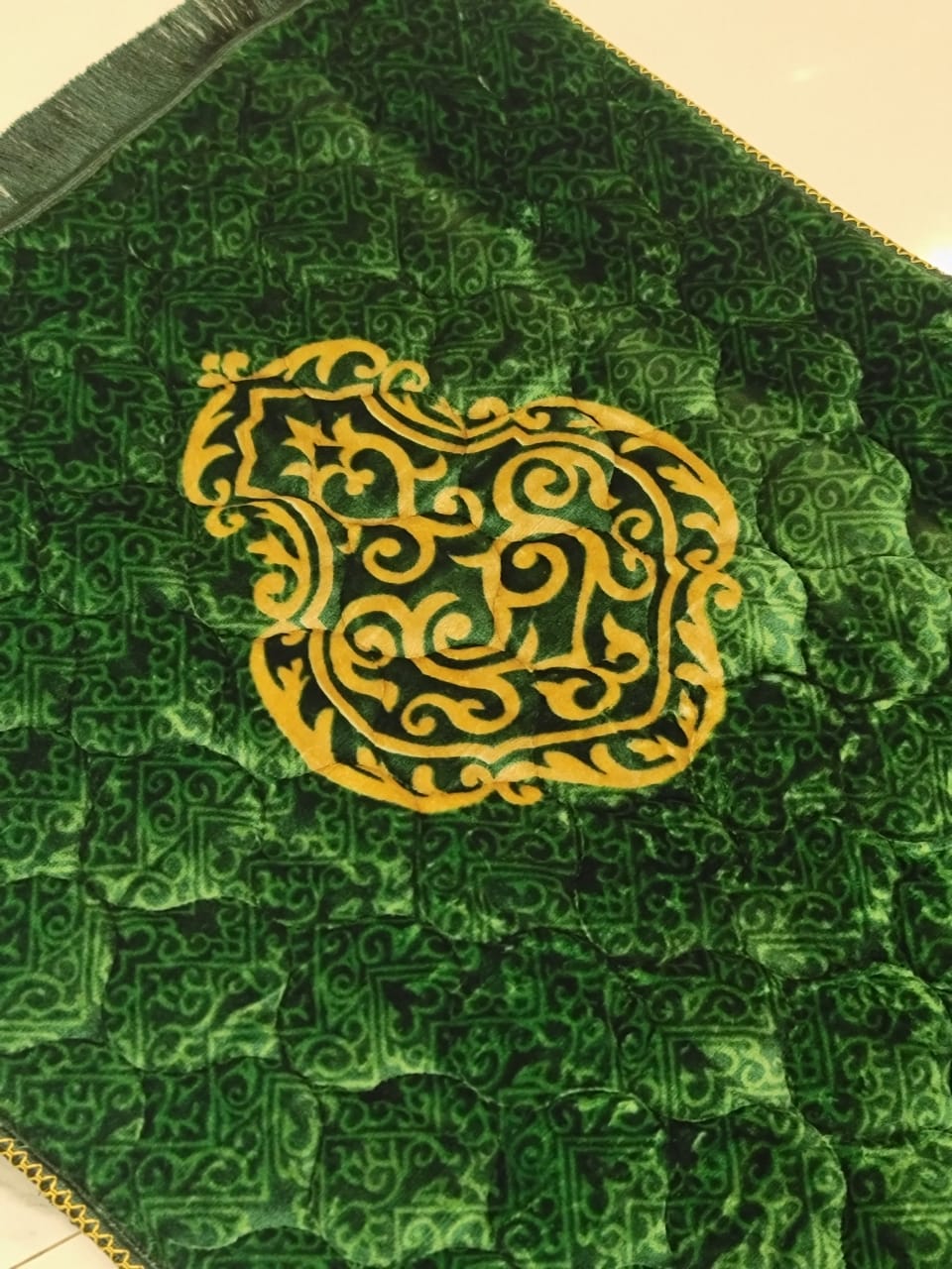 A Green jaynamaz - prayer Mate with a motive design online available at Idara-e-Islamiat, displayed for daily Muslim prayers. 