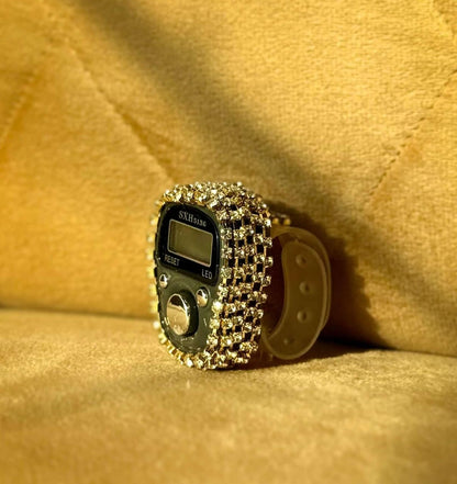 Digital ring with rhinestone embellishments on a beige fabric background