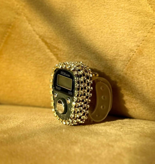 Digital ring with rhinestone embellishments on a beige fabric background